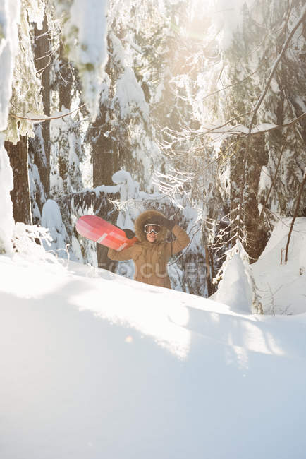 Женщина с сноубордом ходит по заснеженной горе — стоковое фото