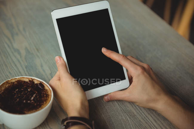 Main de femme en utilisant une tablette numérique dans le café — Photo de stock