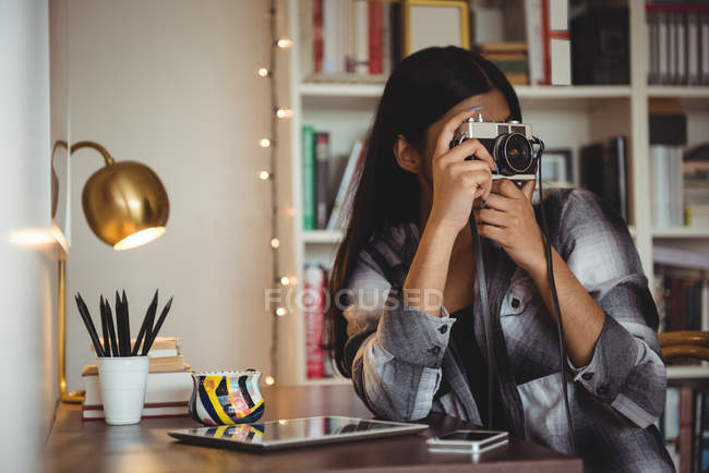 Donna che scatta foto dalla fotocamera in soggiorno a casa — Foto stock