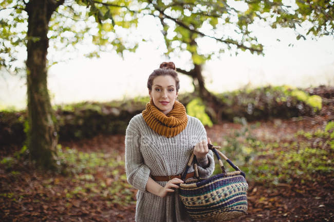 Ritratto di bella donna con cesto passeggiando in campo verde — Foto stock