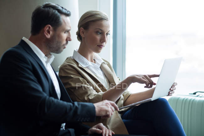 Geschäftsleute diskutieren am Flughafen über Laptop — Stockfoto