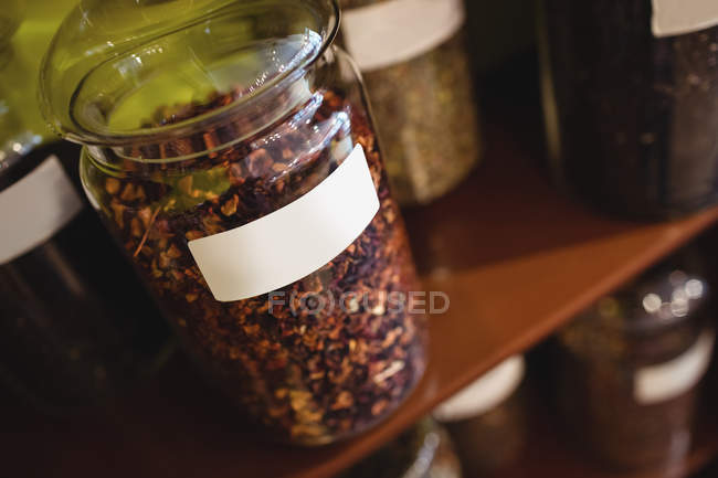 Close-up of various spices jars arranged on shelf in shop — Stock Photo