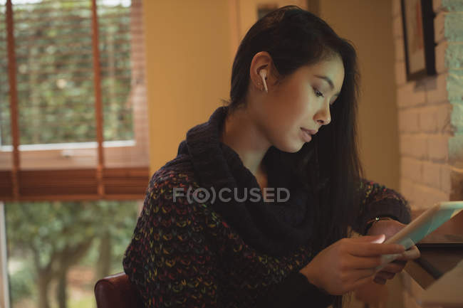 Женщина с цифровым планшетом на кухне счетчик в доме — стоковое фото