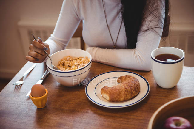 Mulher tomando café da manhã na sala de estar em casa — Fotografia de Stock