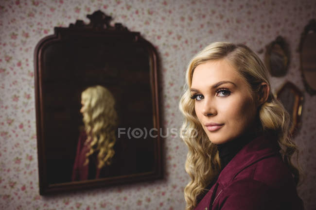 Ritratto di una bella donna in piedi davanti allo specchio — Foto stock