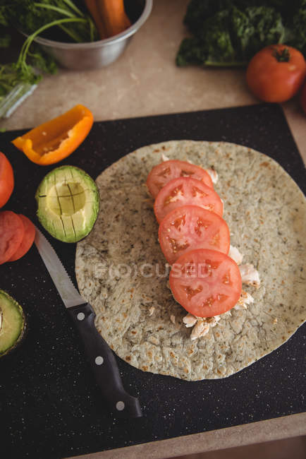 Gros plan sur les ingrédients pour faire du burrito aligné sur le dessus de la table de cuisine — Photo de stock