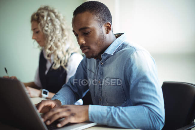Business executives using laptop in office — Stock Photo