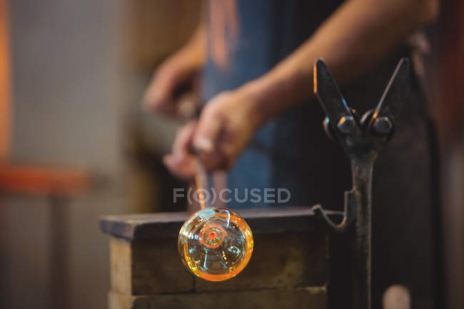 Nahaufnahme eines Glasbläsers, der ein geschmolzenes Glas in der Glasbläserei formt — Stockfoto