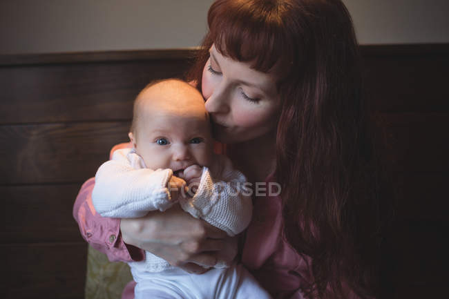 Мать целует ребенка на голову в кафе — стоковое фото