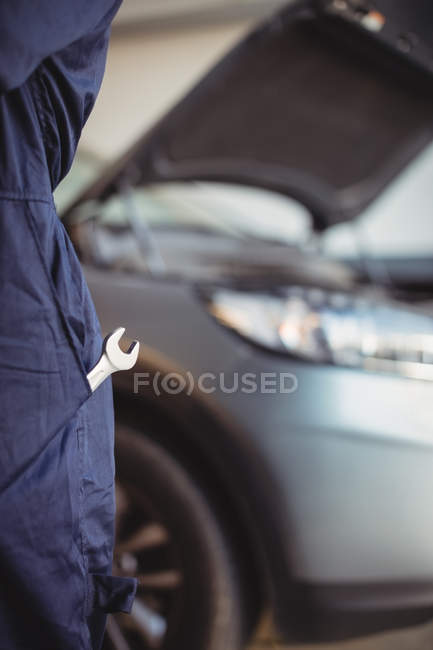Mechaniker mit Schraubenschlüssel in der Tasche in der Garage — Stockfoto