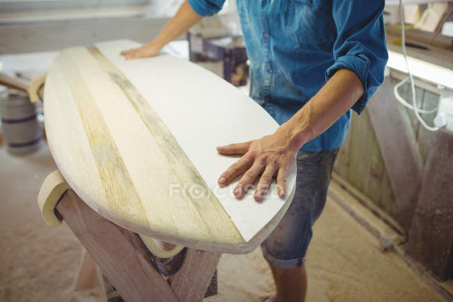 Середина людини, що робить дошку для серфінгу в майстерні — стокове фото