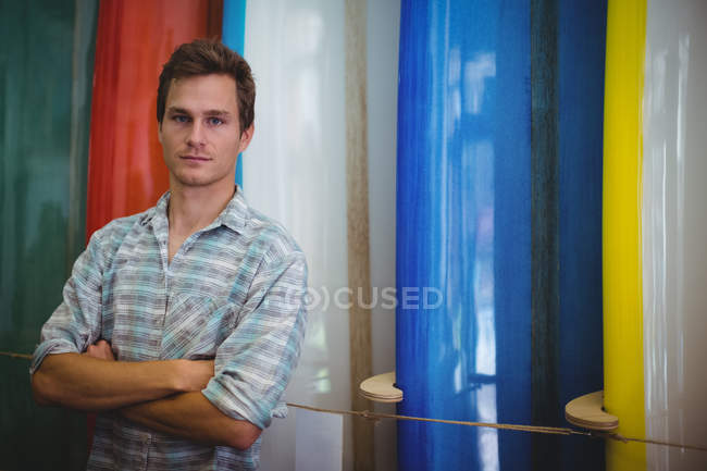 Портрет впевненого чоловіка, що стоїть в магазині серфінгу — стокове фото