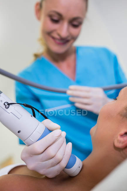 Woman receiving laser epilation treatment on neck at beauty salon — Stock Photo