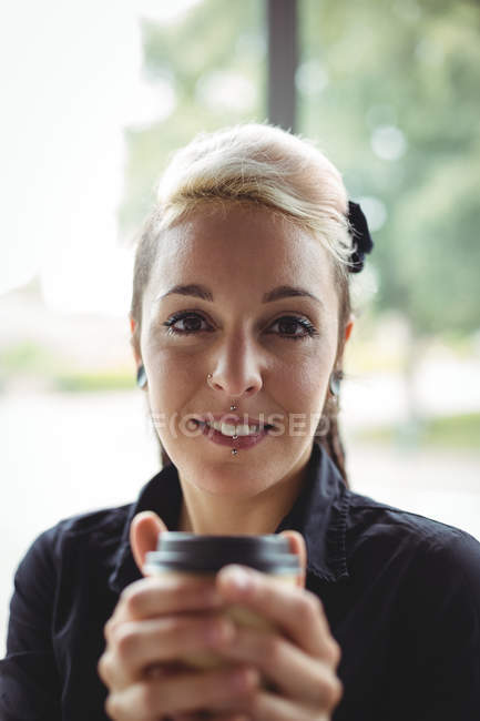 Ritratto di donna che tiene una tazza di caffè usa e getta nel caffè — Foto stock