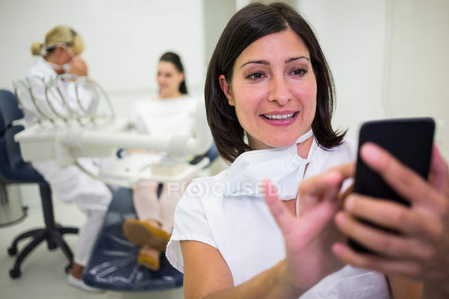 Female doctor using mobile phone at clinic — Stock Photo