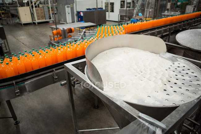 Высокий угол обзора бутылок холодного апельсина на производственной линии на заводе — стоковое фото