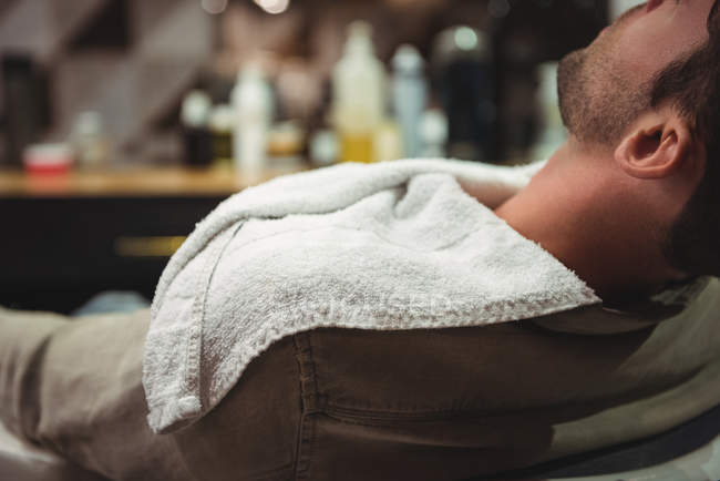 Close-up de cliente relaxante na cadeira na barbearia — Fotografia de Stock