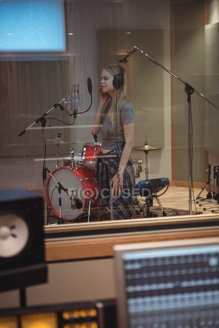 Beautiful woman singing in recording studio — Stock Photo