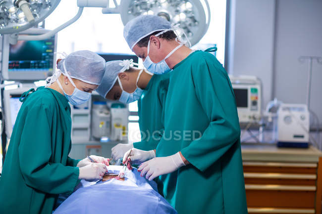 Groupe de chirurgiens effectuant une opération dans le théâtre d'opération de l'hôpital — Photo de stock