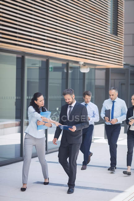 Група впевнених бізнесменів, які виходять за межі офісної будівлі — стокове фото