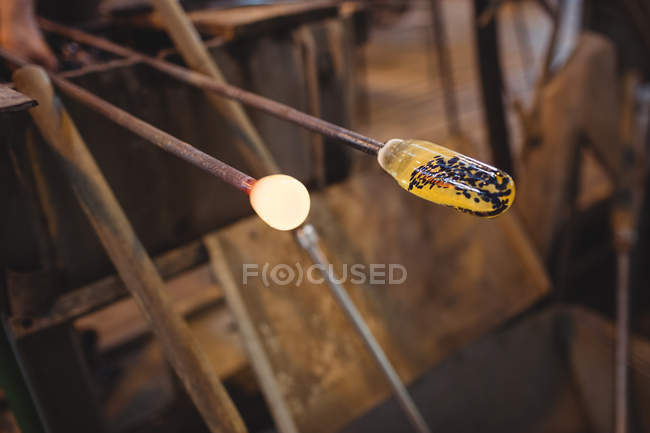 Close-up of molten glass on a blowpipe at glassblowing factory — Stock Photo