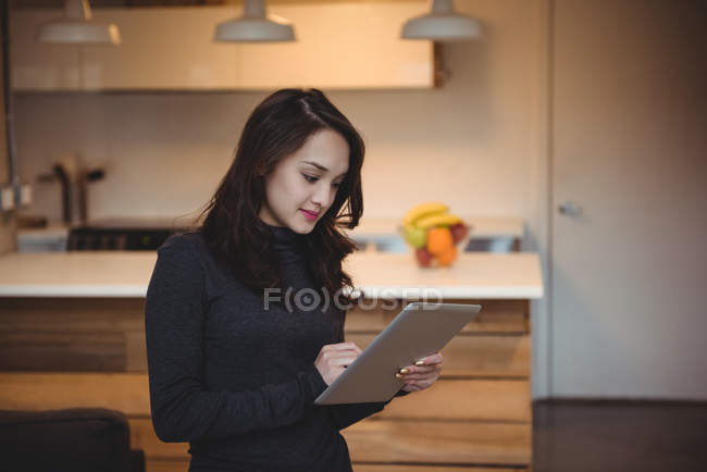 Woman using digital tablet in living room at home — Stock Photo