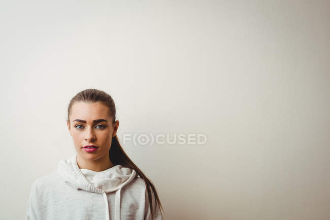 Ritratto di giovane donna contro muro bianco — Foto stock
