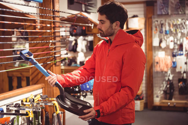 Красивий чоловік вибирає лопату в магазині — стокове фото