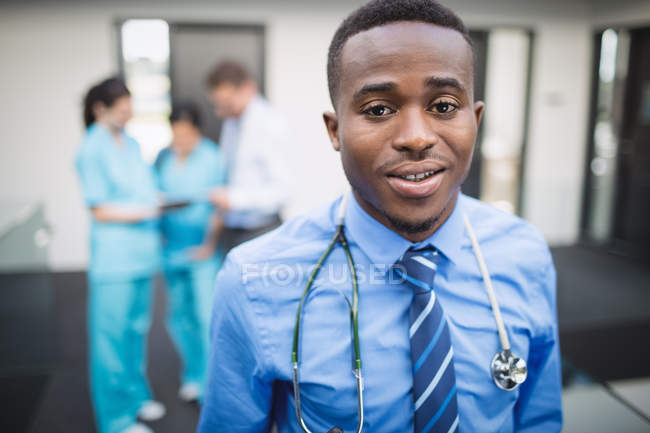 Портрет усміхненого лікаря, що стоїть в лікарняному коридорі — стокове фото
