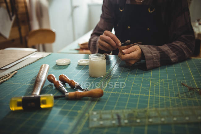 Mid-section of craftswoman preparing leather belt in workshop — Stock Photo