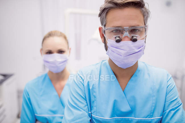 Retrato de dentistas con máscaras en clínica dental - foto de stock