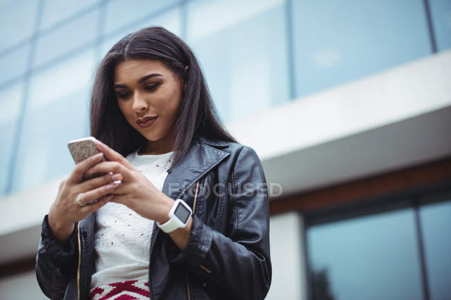 Frau benutzt Handy außerhalb des Bürogebäudes — Stockfoto