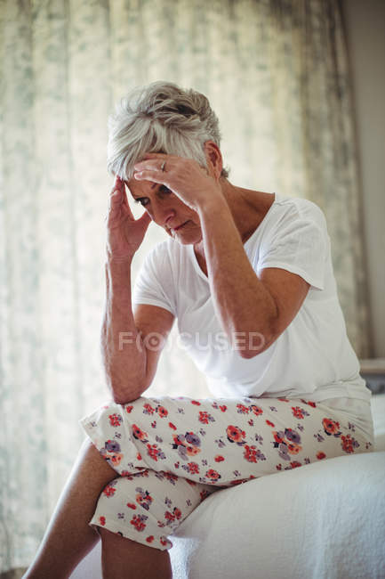 Besorgte Seniorin zu Hause im Schlafzimmer — Stockfoto