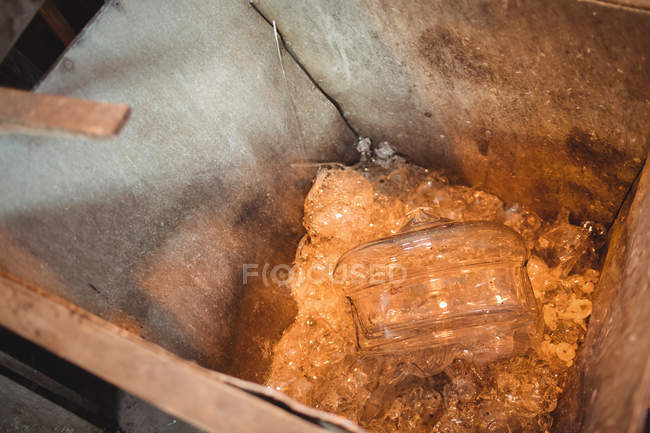 Close-up de resíduos de vidro em um recipiente de metal na fábrica de sopro de vidro — Fotografia de Stock
