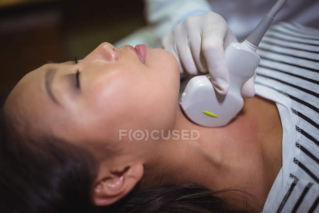 Close-up of female patient receiving a ultrasound scan on the neck — Stock Photo