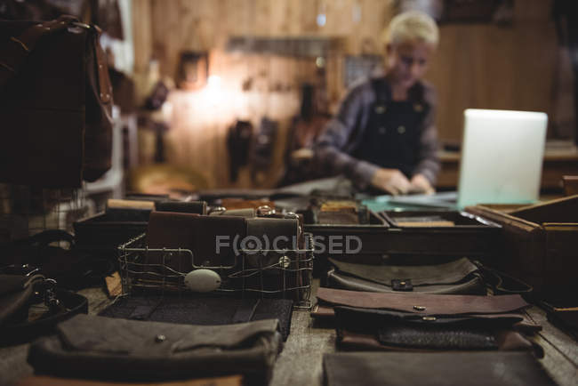 Various leather accessories on table in workshop — Stock Photo