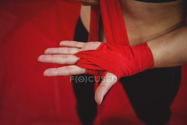 Mid section of female boxer wearing red strap on wrist in fitness studio — Stock Photo