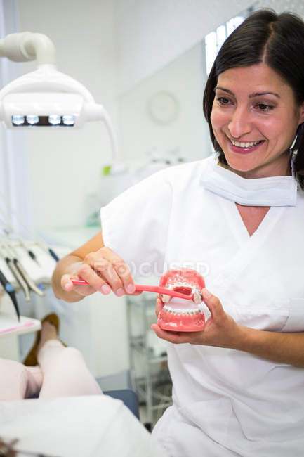 Zahnarzt zeigt Patienten in Zahnklinik, wie man Zähne putzt — Stockfoto