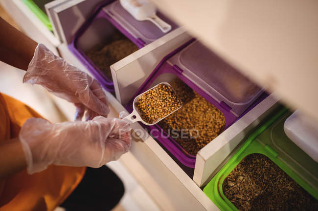 Close-up of shopkeeper holding spices scoop in shop — Stock Photo