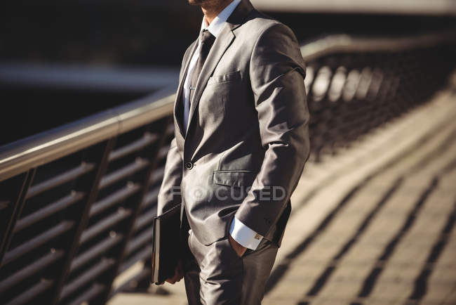 Businessman with a diary standing at office terrace in daylight — Stock Photo