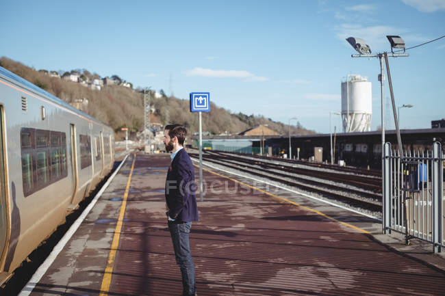 Thoughtful businessman standing at railway station — Stock Photo