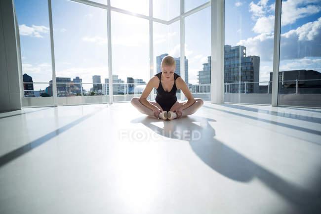 Bailarina realizando um exercício de alongamento no estúdio de balé — Fotografia de Stock