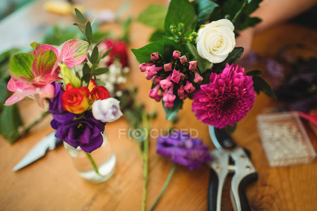 Primer plano de flores en botella en floristería - foto de stock