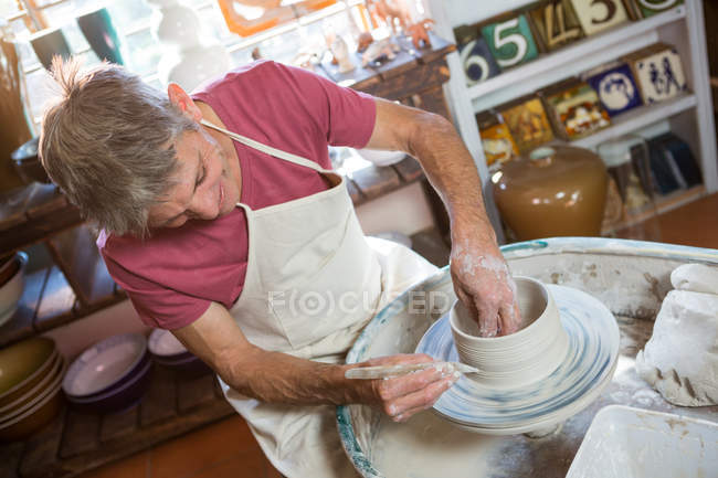 Happy male potter making pot in pottery workshop — Stock Photo
