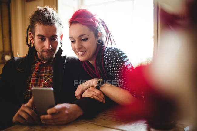 Lächelndes Hipster-Paar nutzt Smartphone zu Hause — Stockfoto