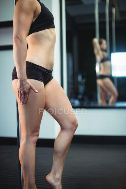 Midsection of pole dancer holding pole in fitness studio — Stock Photo