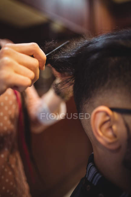 El hombre que se corta el pelo en la peluquería - foto de stock