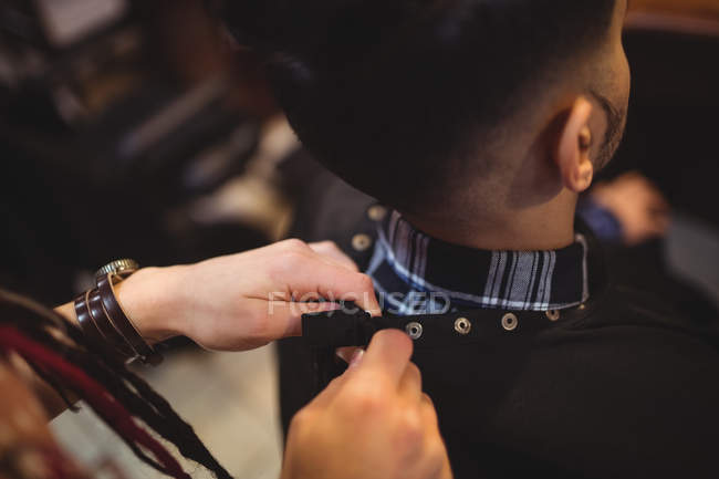 Barbeiro feminino removendo avental cliente na barbearia — Fotografia de Stock