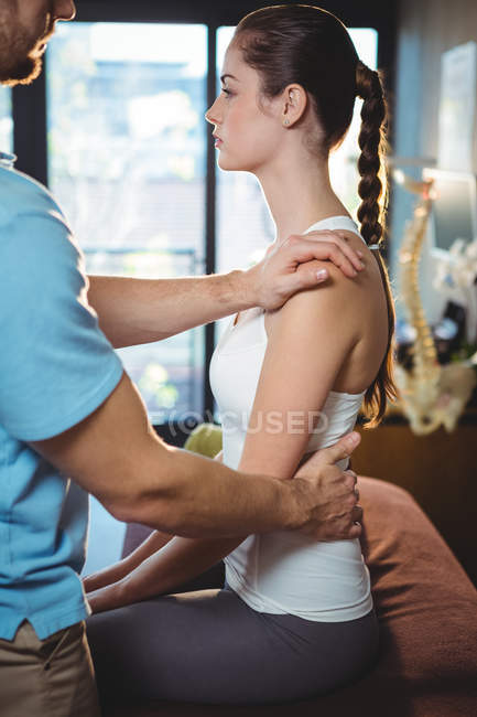 Physiotherapist massaging back of female patient in clinic — Stock Photo
