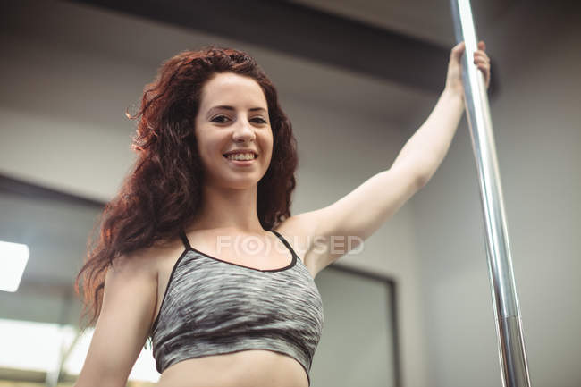 Blick aus der Vogelperspektive auf die Pole-Tänzerin, die die Stange im Fitnessstudio hält — Stockfoto